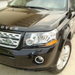 Before and after photographs of a damaged, black, Range Rover that was repaired by Elite Paint & Body Shop in West Palm Beach, FL.